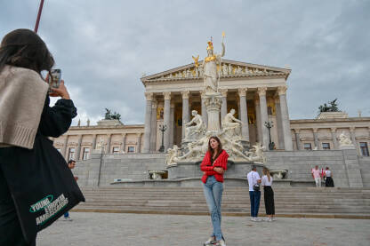 Beč, Austrija: Zgrada austrijskog parlamenta u Beču. Beč, Austrija: Zgrada austrijskog parlamenta u Beču. Turisti se fotografišu ispred parlamenta. Ljudi na trgu.