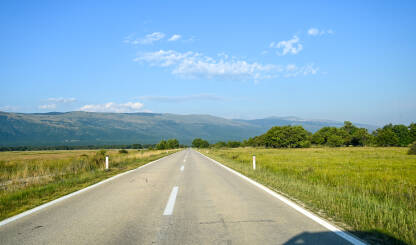 Duga ravna cesta u polju. Duga ravna cesta u polju. Vožnja automobila u prirodi. Pogled vozača na asfaltnu cestu. Livanjsko polje.
