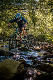 Čovjek na biciklu u šumi Vožnja MTB bicikla kroz potok.