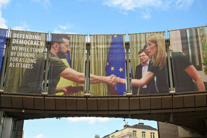 Brisel, Belgija: Volodimir Zelenski, predsjednik Ukrajine, na bilbordu Evropske unije. Bilbord na zgradi koji prikazuje rukovanje ispred zastave EU. Institucije Evropske unije.