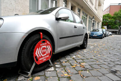 Nepropisno parkiranje u Bratislavi Auto sa blokiranim točkovima zbog nepropisnog parkiranja na ulici. Parkirani automobil sa crvenom bravom na gumama. Blokada točkova.