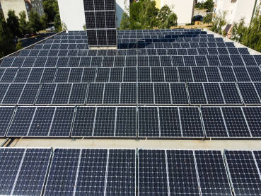 Solarni paneli na krovu. Solarni paneli na krovu objekta. Snimak dronom na solarne panele na vrhu zgrade. Proizvodnja čiste obnovljive energije iz sunca. Fotonaponske solarne ćelije. Električna energija.