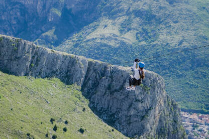 Djevojka se spušta niz Zip Line kabl sa pogledom na Mostar