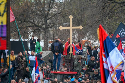 Mladić drži veliki krst na studentskom protestu u Begradu 15. marta 2025. godine. Studenti i građani traže pravdu za poginule tokom pada nadstrešnice u Novom Sadu.
