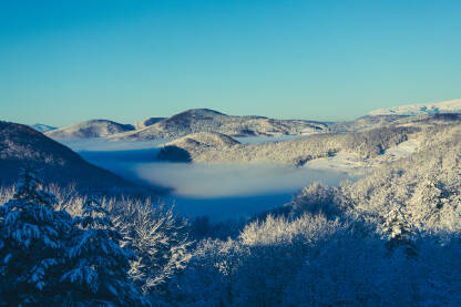 Dolina u magli i planine u suncu, centralna Bosna, jutro