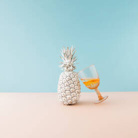 Ananas Svježi ananas obojen u bijelu boju i časa s pićem.