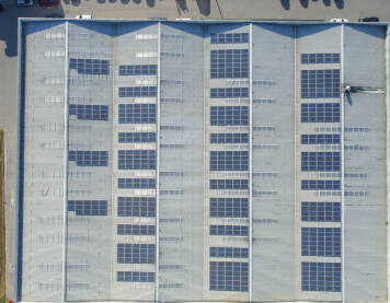 Krov fabrike sa fotonaponskim solarnim panelima, snimak dronom. Skladište opremljeno solarnim energetskim sistemom. Solarni paneli.