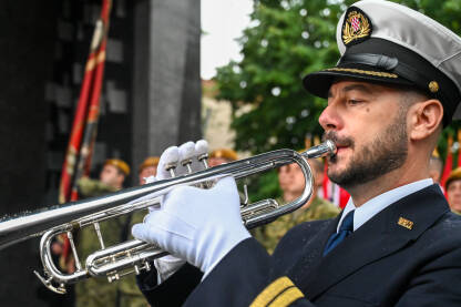 Muškarac svira trubu Muzičar s trubom. Vojnik u bijelim rukavicama svira trubu. Vojni orkestar na paradi.