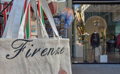 Italijanska moda Ceger sa natpisom Firenca, dok je u pozadini butik sa ženskom odjećom. Šoping u Italiji.