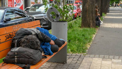 Čovjek spava na ulici. Muškarac spava u gradu na otvorenom. Beskućnici.