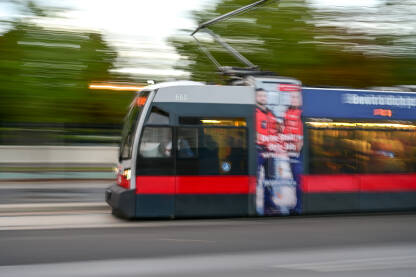 Tramvaj se brzo kreće ulicom. Beč, Austrija: Tramvaj se brzo kreće ulicom. Javni gradski prijevoz. Zamućena fotografija tramvaja.