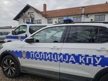 Policijska vozila parkiran ispred ulaza u kazneno popravni zavod u Bijeljini. Vozila u prvom planu, ulaz u zgradu se vidi u pozadini.