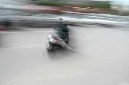 Motociklista na motoru brzo vozi kroz grad. Motociklista na motoru brzo vozi kroz grad, blurana fotografija. Vožnja motocikla.