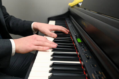 Muškarac svira klavir. Pijanist svira na instrumentu kod kuće. Muzički instrumenti. Električna klavijatura.