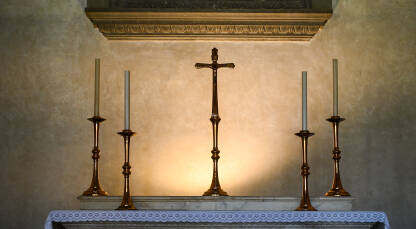 Križ na oltaru u katoličkoj crkvi. Križ i svijeće.