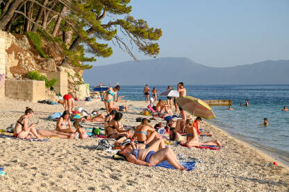 Turisti se kupaju na moru i sunčaju na plaži na Jadranskom moru. Turisti se kupaju na moru i sunčaju na plaži na Jadranskom moru. Turizam u Hrvatskoj ljeti.