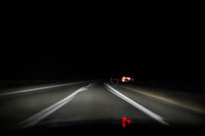 Vožnja pod utjecajem alkohola ili umora. Zamagljen pogled vozača na asfaltnoj cesti. Vožnja pod utjecajem alkohola ili umora. Vožnja automobila noću.