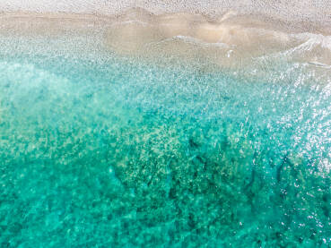 DJI_0201 Prekrasna tropska pješčana plaža tokom ljeta, snimci dronom. Morski valovi na pješačnoj obali. Prozirno tirkizno more.