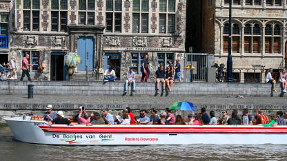 Ghent, Belgija. Turisti u čamcima istražuju grad. Historijske zgrade i rijeka u gradu.