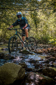 Čovjek na biciklu u šumi Vožnja MTB bicikla kroz potok.