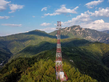 GSM i radio telekomunikacioni toranj na vrhu brda GSM i radio telekomunikacioni toranj na vrhu brda. Predajnik mobilnih operatera, snimak dronom iz zraka. Bazna primopredajna stanica. Bežični komunikacioni antenski predajnik.
