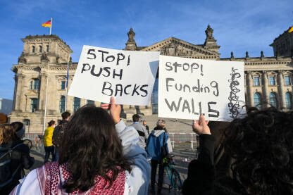 Protesti protiv prisilnih vraćanja izbjeglica i migranata Berlin, Njemačka: Aktivisti na protestima. Žene drži transparente ispred Bundestaga u Berlinu. Pro migrantske demonstracije.