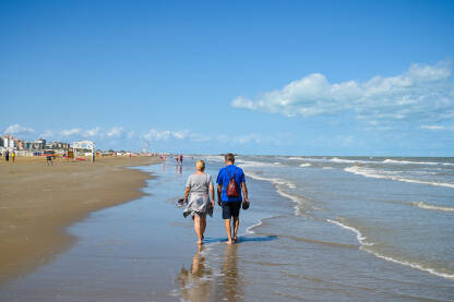 Par šeta pješčanom plažom uz more Par šeta pješčanom plažom uz more.
