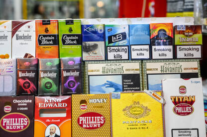Kutije cigareta na policama u supermarketu. Kutije cigareta na policama u supermarketu. Kutije cigara sa upozorenjima. Duhan. Natpisi: Pušenje ubija.