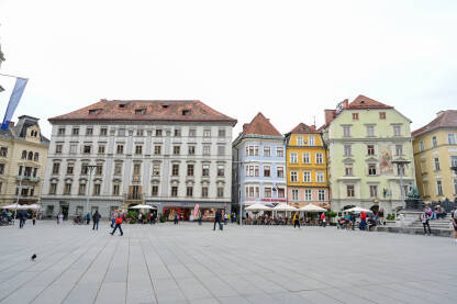 Graz, Austrija: Grupa ljudi na glavnom trgu u centru grada. Graz, Austrija: Grupa ljudi na glavnom trgu u centru grada. Historijske zgrade na glavnom trgu ili Hauptplatzu. Stari grad Graz. Erzherzog-Johann-Brunnen fontana.