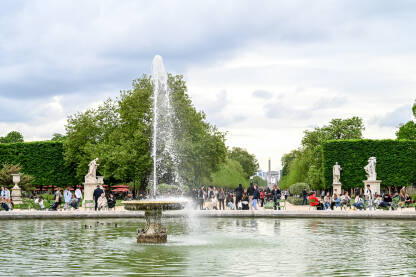 Pariz, Francuska: fontana Grand Bassin Rond. Pariz, Francuska: fontana Grand Bassin Rond. Grupa ljudi koji šeta vrtom Tuileries. Turisti istražuju grad.