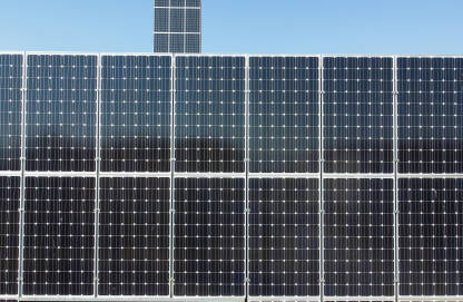 Solarni paneli na krovu. Solarni paneli na krovu objekta. Snimak dronom na solarne panele na vrhu zgrade. Proizvodnja čiste obnovljive energije iz sunca. Fotonaponske solarne ćelije. Električna energija.