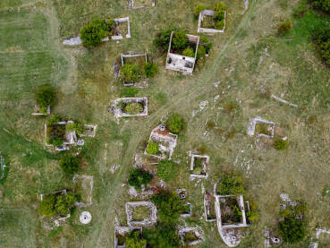 Uništeno selo u ratu, snimak dronom. Srušene i oštećene kuća u selu kao posljedica rata. Kuće uništene i spaljene artiljerijom tokom rata. Kuće u ruševinama.