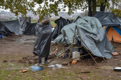 Improvizovani migrantski kamp Čovjek stoji u blatu, između improvizovanih šatora za izmjeglice i migrante u Velikoj Kladuši, Bosna i Hercegovina.