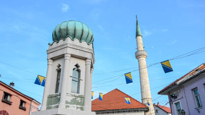 Tuzla, Bosna i Hercegovina Tuzla, Bosna i Hercegovina. Glavni trg u centru grada. Minaret i džamija. Zastava Bosne i Hercegovine.