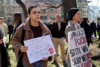 Dvije žene na protestima u Sarajevu drže ručno ispisane transparente s porukama protiv korupcije i zaštite onih koji su počinili nepravdu