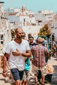 Turisti u šetnji Turisti koriste lijepi sunčan dan za šetnju u gradu Alberobello.
