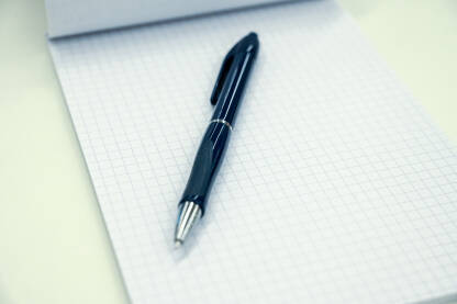 Hemijska olovka i blok za pisanje. Hemijska olovka i blok za pisanje. Pribor za pisanje na stolu. Olovka i notes.