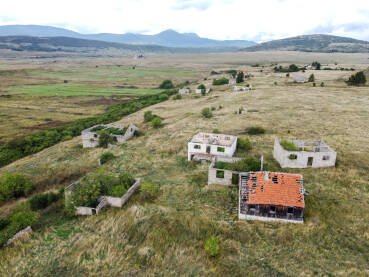 Uništeno selo u ratu, snimak dronom. Srušene i oštećene kuća u selu kao posljedica rata. Kuće uništene i spaljene artiljerijom tokom rata. Kuće u ruševinama.