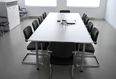Moderna konferencijska sala s bijelim modularnim stolom na i crnim stolicama. Savremena sala za sastanke. Moderna kancelarija