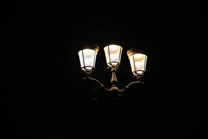Ulična rasvjeta. Svjetiljka noću u gradu. Električna ulična lampa u gradu. Ulična rasvjeta. Upaljena svjetiljka u gradu noću.