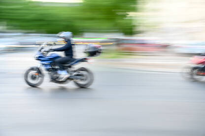 Motocikl se kreće brzo na ulici. Vozač vozi motor u gradu. Motociklista na motoru.