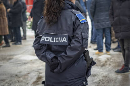 Policajka u uniformi, sa pištoljem Policajka okrenuta leđa u uniformi Mup-a KS.Policajka na obezbjeđenju