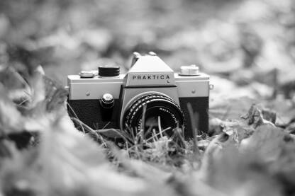 Analogni fotoaparat Praktica Analogni fotoaparat Praktica L. Stari analogni fotoaparat u jesen na opalom lišću.