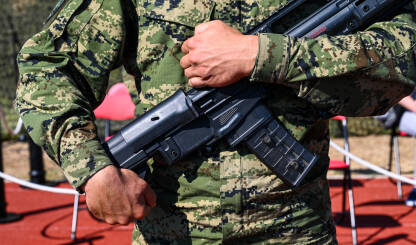 Vojnik Vojnik u uniformi drži automatsku pušku.