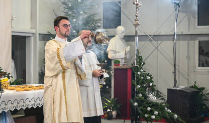 Svećenik zamahuje kadilom. Misa polnoćka. Zagreb, Hrvatska: Katolički svećenici u liturgijskom ruhu se mole. Svećenik zamahuje kadilom. Kršćanski svećenici se mole u katedrali. Misa polnoćka u crkvi.