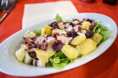 Salata od hobotnice Salata od hobotnice s krumpirom, lukom i zelenom salatom.