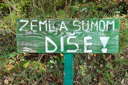 Tabla na trim stazi. Trim staza u prirodi. Tabla na trim stazi. Natpis - Zemlja šumom diše.