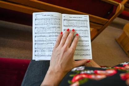 Djevojka se moli u adventističkoj crkvi Djevojka se moli u crkvi. Žena drži knjigu tokom molitve. Vjernici se mole.