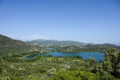 Baćinska jezera Prirodno plavo jezero između zelenih brežuljaka. Baćinska jezera, Ploče, Hrvatska. Panoramski pogled na Baćinska jezera.