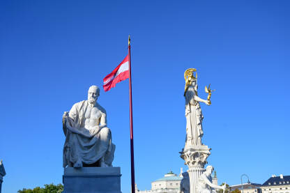 Beč, Austrija: Spomenik ispred zgrade austrijskog parlamenta. Beč, Austrija: Spomenik ispred zgrade austrijskog parlamenta. Zastave Austrije ispred parlamenta.